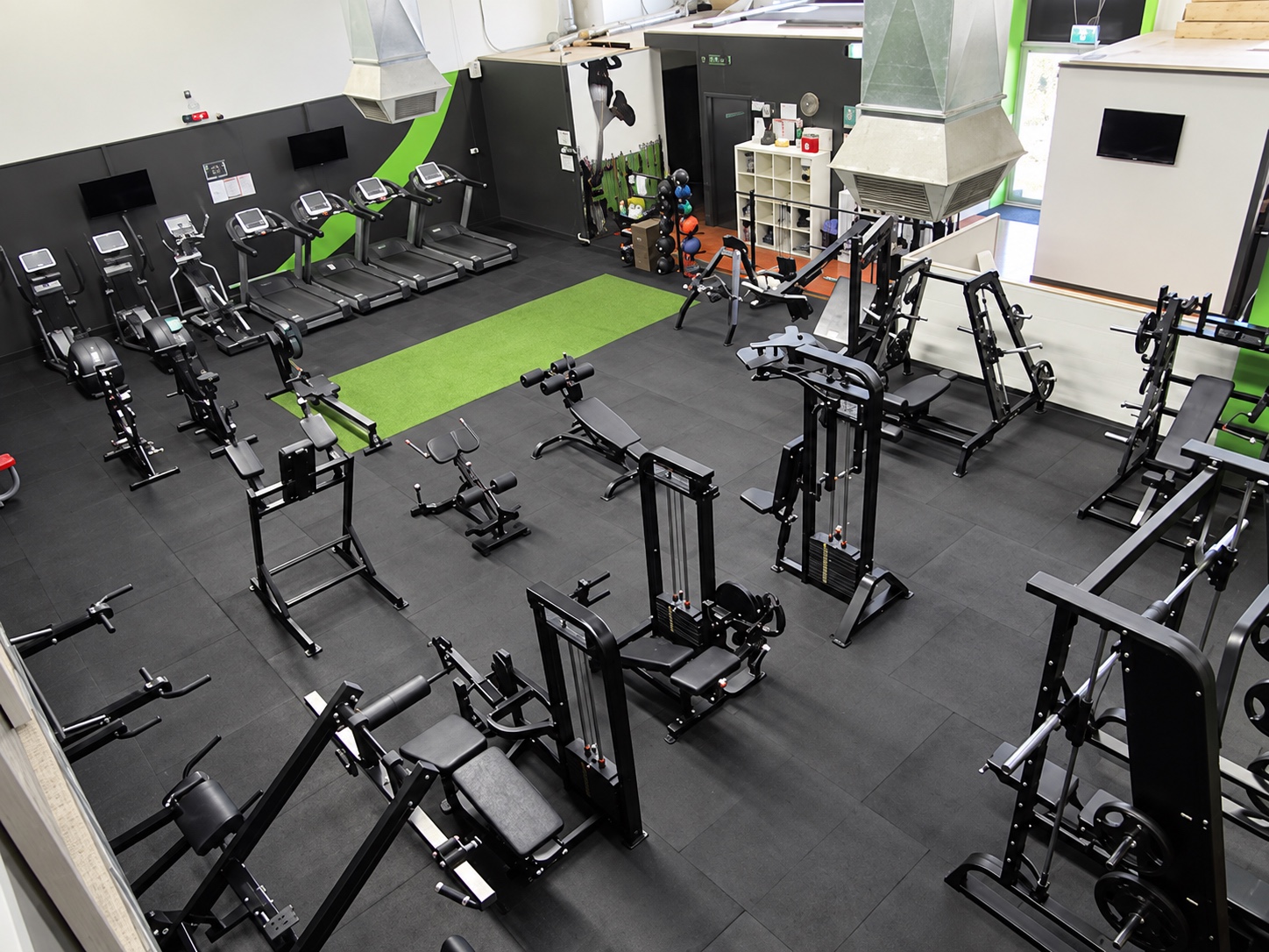 Elevated view of the Your Story gym with strength equipment and green turf